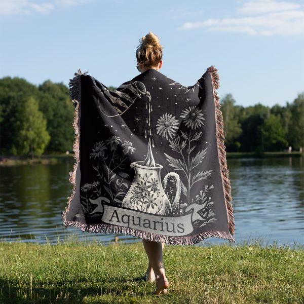 Woman wrapped in Aquarius Flow woven blanket, water pouring design visible from behind.