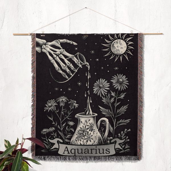 Aquarius Flow woven blanket hung on wall as tapestry, featuring skeleton hand with water and floral elements.