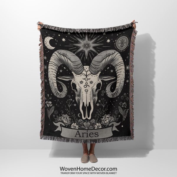 Woman holding the Aries Spirit woven blanket with a buffalo skull design; woman not visible.