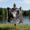 Woman wrapped in Aries Spirit woven blanket, buffalo skull design visible from behind.