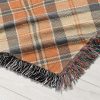 Close-up of the texture of the "Best Dad Ever" blanket with orange and gray plaid, highlighting the weaving quality and design details.