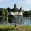 Woman with her back turned, wrapped in the "Best Grandpa Ever" blanket, showing its size and cozy plaid pattern.