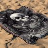 Cancer Spirit woven blanket with crab and human skull lying on sandy surface.