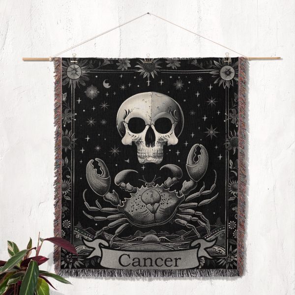 Cancer Spirit woven blanket hung on wall as tapestry, highlighting crab, skull, and floral details.