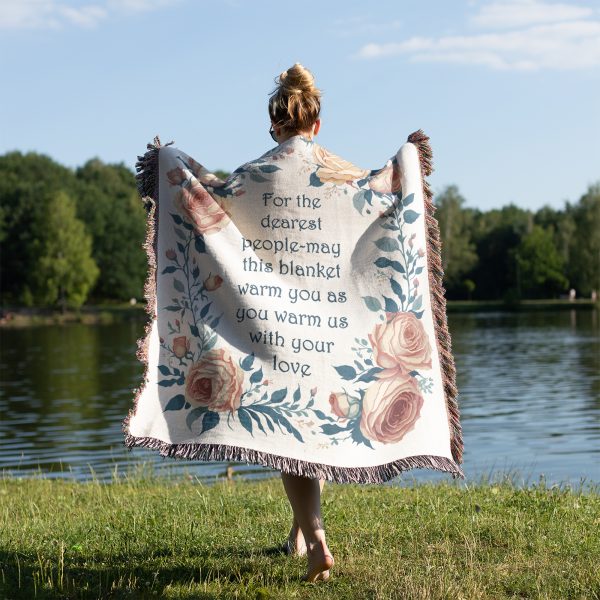 Woman wrapped in the "Dearest People Woven Blanket," surrounded by fall leaves, highlighting its warmth and elegant design.