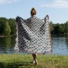 Woman wrapping herself in Japanese style woven blanket, back view, with soft, subtle patterns.