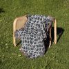 Japanese style woven blanket on chair outdoors, creating a peaceful and natural ambiance.