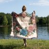 Woman with her back turned, wrapped in the "Love Blooms Woven Blanket," highlighting its romantic design and size.