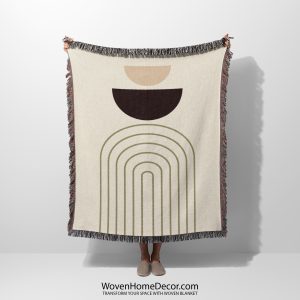 Person holding the Modern Arc Woven Blanket featuring soft curved lines in earthy tones on a light background.