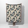 Ocean Bloom Woven Blanket with blue floral pattern held by woman, showcasing full design on white background.