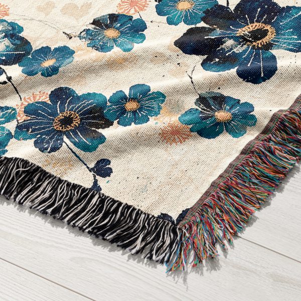 Close-up of Ocean Bloom Woven Blanket, highlighting intricate blue floral details on white background.