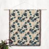 Ocean Bloom Woven Blanket displayed as wall tapestry, blue floral pattern enhancing interior decor with modern touch.