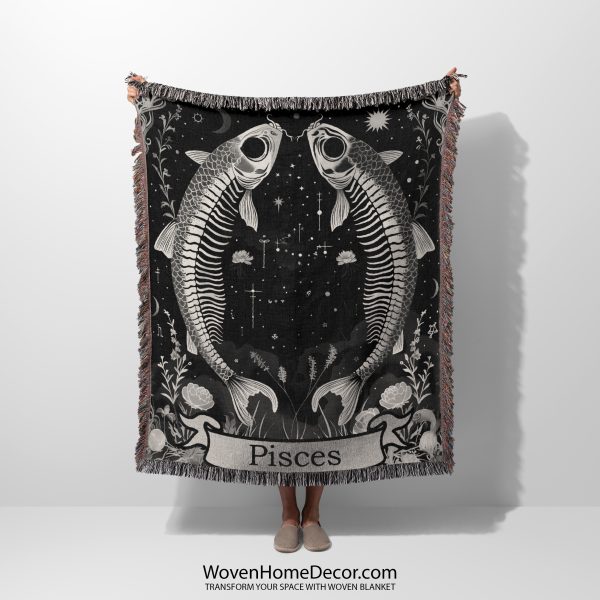 Woman holding the Pisces Dream woven blanket with twin fish skeletons; woman not visible.