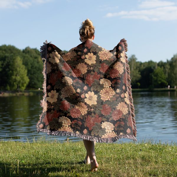 Woman wrapped in floral woven blanket, back view, with large flower patterns in vivid colors.