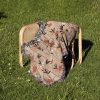 Floral woven blanket on chair, with delicate, small flowers in pastel shades, creating a soft, calm atmosphere.