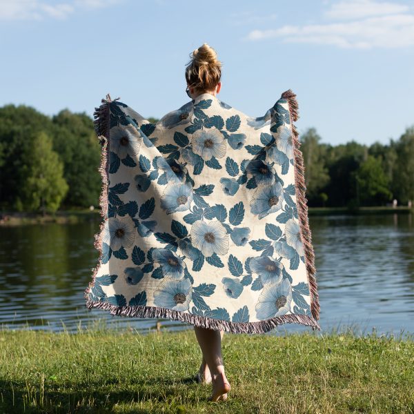 Woman wrapped in floral woven blanket, back view, with soft, romantic flower patterns in light pastel colors.