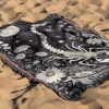 Scorpio Mystery woven blanket with scorpion lying on sandy surface.