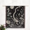 Scorpio Mystery woven blanket hung on wall as tapestry, highlighting scorpion with stars and flowers.