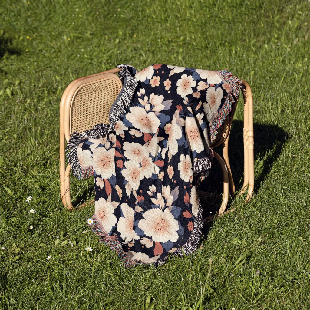 Floral woven blanket on chair, featuring exotic, tropical flowers in bright, lively hues for an energetic atmosphere.