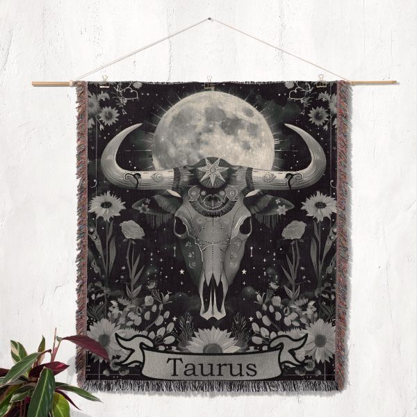 1. Taurus Earth woven blanket hung on wall as tapestry, featuring detailed calf skull and floral design.