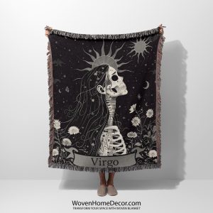 Woman holding the Virgo Grace woven blanket with female skeleton in profile; woman not visible.