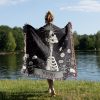 Woman wrapped in Virgo Grace woven blanket, profile skeleton design visible from behind.