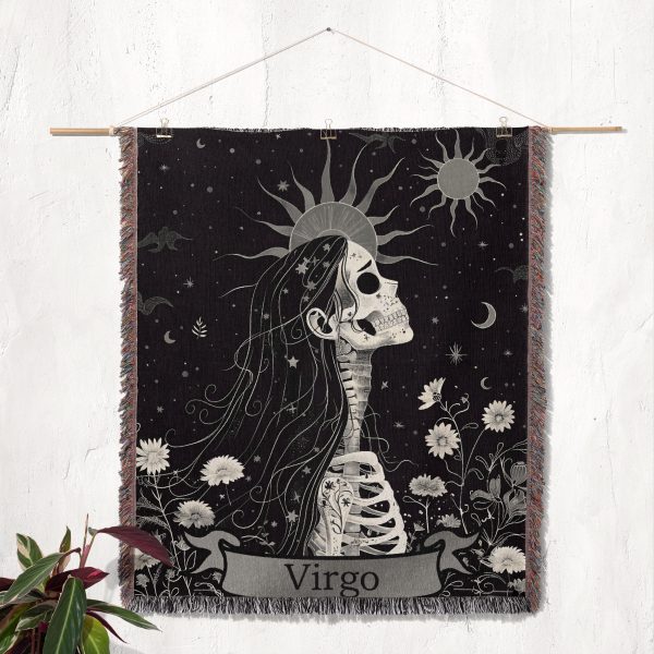 Virgo Grace woven blanket hung on wall as tapestry, showcasing skeleton profile with floral details.