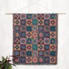 Indian style woven blanket hanging on wall as tapestry, featuring vibrant paisley patterns and traditional motifs.