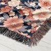 Close-up of floral woven blanket, showcasing intricate flower designs in a palette of soft pastels.