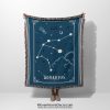 A person holding an Aquarius zodiac woven blanket, with an intricate water-bearer constellation design in cool blues and silver accents.