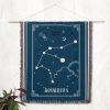 The Aquarius zodiac woven blanket hanging as a tapestry, with its water-bearer constellation and soothing blue hues adding a peaceful, celestial touch to the room.