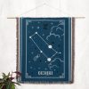 The Gemini zodiac woven blanket displayed as a wall tapestry, adding a celestial touch to the room with its twin motifs and starry background.