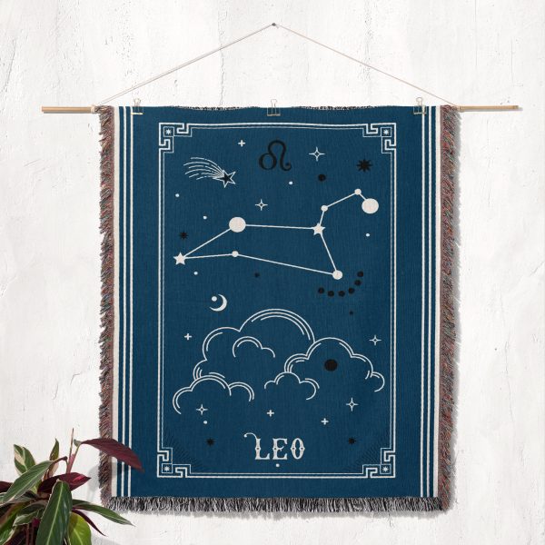 The Leo zodiac woven blanket hanging as a tapestry on the wall, showcasing the vibrant lion constellation in bold colors.