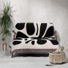 Modern Abstract Woven Blanket draped over a sofa, adding bold contrast to the room.