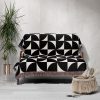 Modern Geometric Woven Blanket draped over a sofa, adding graphic contrast to the space.