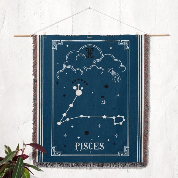 The Pisces zodiac woven blanket displayed as a tapestry on the wall, with the twin fish design and soothing colors creating a calming focal point.