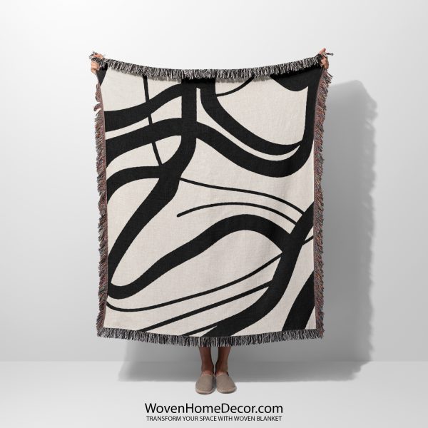 A Scandinavian Abstract Woven Blanket held by a person; only the abstract black-and-white design is visible.