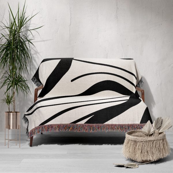 A Scandinavian Abstract Woven Blanket draped over a sofa, creating a bold decorative accent.