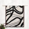 The Scandinavian Abstract Woven Blanket hanging on a wall as a striking tapestry.