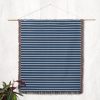 The Scandinavian Blue Striped Woven Blanket hanging on a wall as tapestry decor.