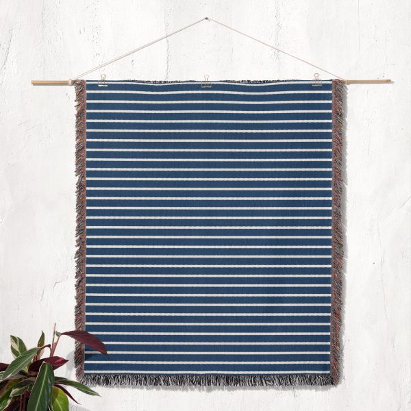 The Scandinavian Blue Striped Woven Blanket hanging on a wall as tapestry decor.