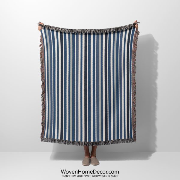 A Scandinavian Striped Woven Blanket held by a person; only the blanket’s striped design is visible.