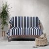 A Scandinavian Striped Woven Blanket elegantly draped over a sofa, creating a cozy look.