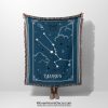 A person holding a Taurus zodiac woven blanket, featuring earthy tones and the Taurus constellation surrounded by soft, celestial patterns.