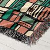 Detailed view of the geometric-patterned woven blanket, showcasing intricate textures.