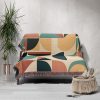 Sofa covered with a geometric patterned woven blanket in vibrant colors, adding a creative touch to the room.