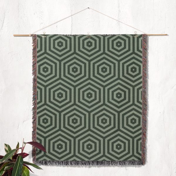 The woven blanket displayed on the wall as a modern tapestry with geometric patterns.