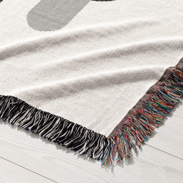 Close-up of the woven blanket’s abstract monochrome design in black, gray, and white tones.