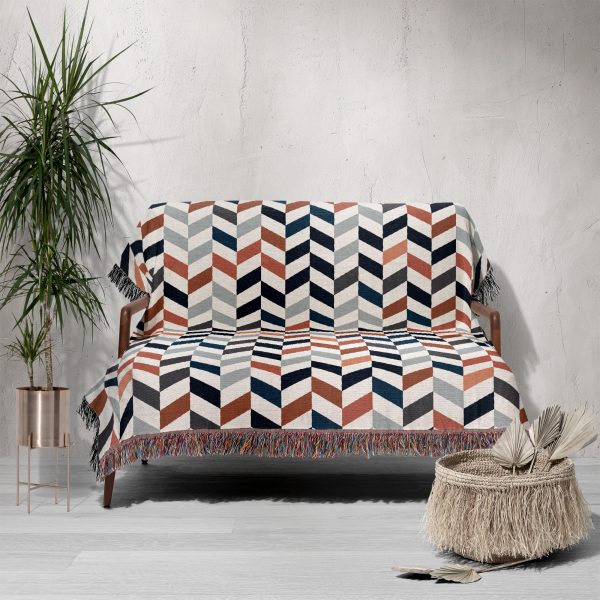 Scandinavian Chevron Harmony Woven Blanket draped over a sofa in a cozy setting.