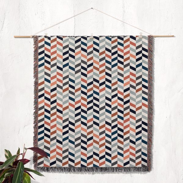 Scandinavian Chevron Harmony Woven Blanket displayed on a wall as a tapestry.